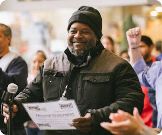 A person at Homeboy holding their mission statement paper.